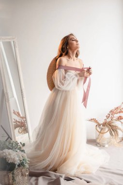 Gelinlik giymiş şapkalı güzel gelin. Stüdyoda poz veren mutlu yeni evli kadın. Düğün makyajlı ve saç stili gelin. Düğün günü ve evlilik kavramı 