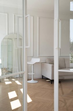 Beyaz duvarları, modern mobilyaları ve doğal ışığı olan minimalist iç mekan..