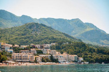 Kıyı kasabası, yemyeşil dağlara ve sakin denize yuva yapmış binalar..