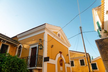 Sarı binaları ve mavi gökyüzü olan Büyüleyici Akdeniz köyü.