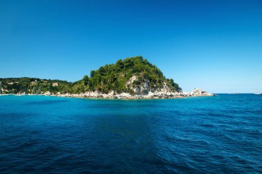 Bereketli yeşilimsi, berrak mavi okyanusla çevrili berrak bir ada..