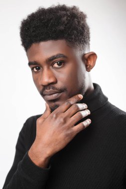 Kameraya bakan, çenesine dokunan, beyaz stüdyo arka planında izole edilmiş dalgın bir adamın portresi. Düşünceli adam düşünüyor ve karar veriyor. 