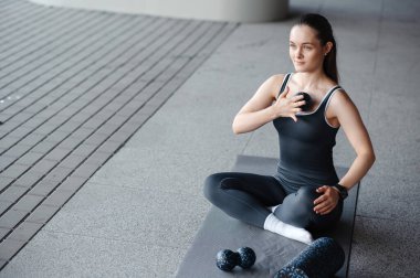 Gri spor kıyafetli, dışarıda masaj toplarıyla yoga yapan hoş bir kadın.