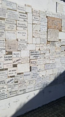 Karmaşık metinlerle süslenmiş, elle oyulmuş ve elementlere maruz bırakılmış bir duvar gizem ve antik bilgeliği çağrıştırıyor.