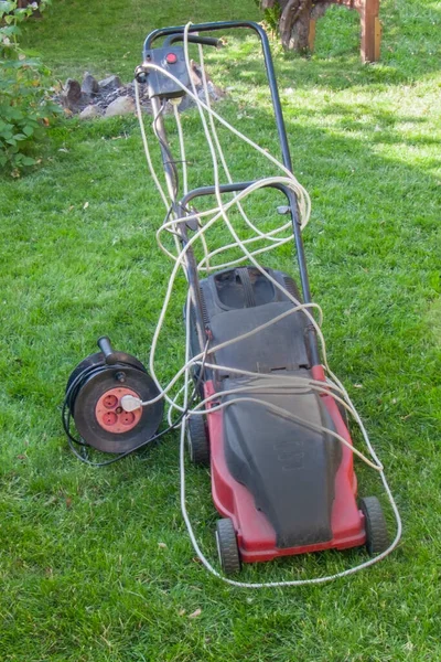 赤い電気芝刈り機 緑のカットされた芝生 閉じる — ストック写真