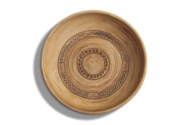 Yuvarlak el yapımı kil levhanın yakın çekimi. Okunmamış doku ve oyulmuş basit bir süs görülebilir. Sıcak toprak rengi ve doğal görünüş ürünün çevreci dostluğunu ve benzersizliğini vurgular.