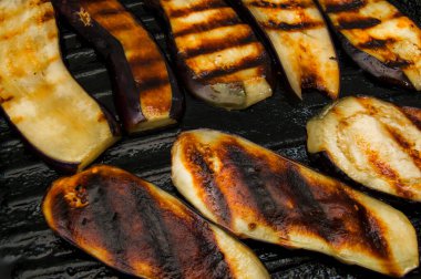 Karakteristik çizgileri olan ızgara tavasında iştah açıcı kızarmış patlıcan dilimleri. Sağlıklı yemek tarifleri için ideal..