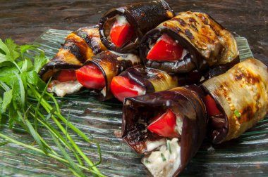 Taze domatesli, sarımsaklı ve otlu kızarmış patlıcan. Ahşap bir tahtada kompozisyon, mutfak temaları için ideal..