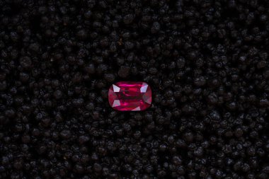 red stone ruby on black background with granules clipart