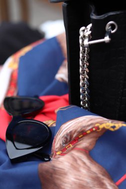 Kadının güneş gözlüğünü ve çantasını kapat.