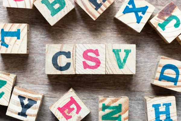 Alphabet letter block in word CSV (Abbreviation of Computer system validation or Comma-separated values) and another letter on wood background