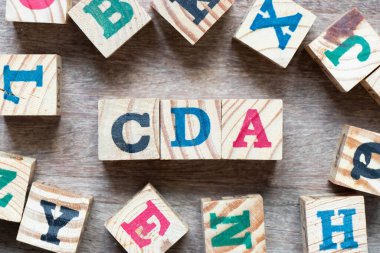 Kelime CDA ile alfabe harfi bloğu (Gizli Açıklama Anlaşmasının kısaltması) ve tahta zemin üzerine başka bir harf