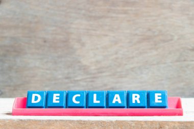 Ahşap arkaplanda kırmızı renk rafında kelime beyanı olan döşeme alfabesi harfi