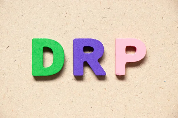 Color alphabet letter in word DRP (Abbreviation of Disaster recovery plan, Distribution resource planning, Dividend reinvestment plan, Direct Repair Program or Digital Remaster Processing) on wood background
