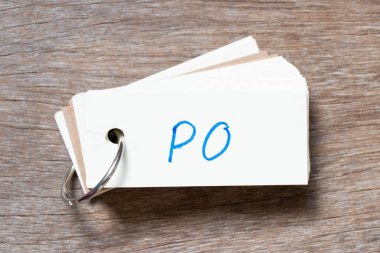 Tahta zemin üzerinde kelime PO (satın alma emrinin kısaltması) ile el yazısı olan flaş kart