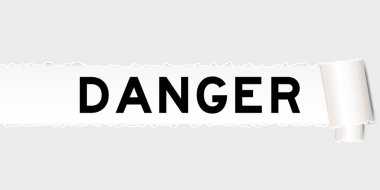 Parçalanmış parçanın altında kelime tehlikesi olan yırtılmış gri kağıt arkaplan