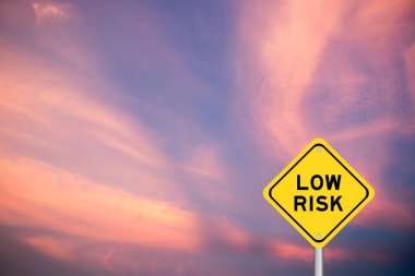 Sarı taşıma işareti ile menekşe rengi gökyüzü arka planında düşük risk