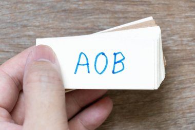 Ahşap zemin üzerinde el yazısı ile AOB (sosyal yardım atamasının kısaltılmışı veya herhangi başka bir işletme) olan el bilgisayarı flaş kartı