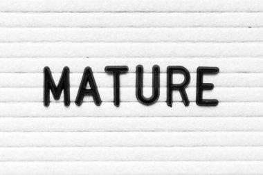 Siyah alfabe harfi beyaz keçeli tahta arka planında olgunlaşmış.