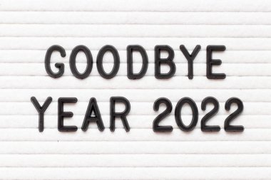 Black color letter in word goodbye year 2022 on white felt board background clipart