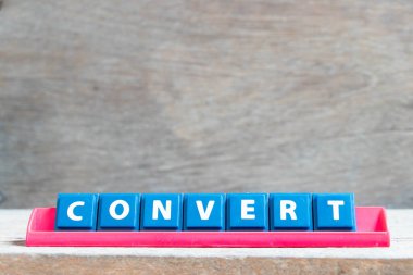 Tile alphabet letter with wordconvert  in red color rack on wood background