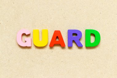 Color alphabet letter with word guard on wood background