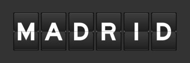 Black color analog flip board with word madrid on gray background
