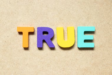 Color alphabet letter in word true on wood background