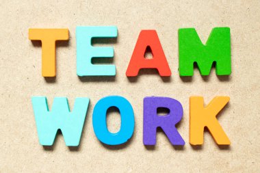 Color alphabet letter in word teamwork on wood background