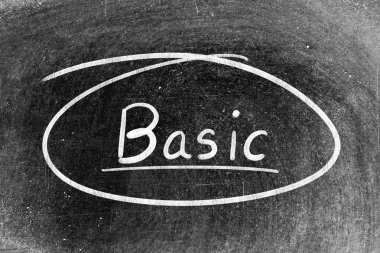 Beyaz tebeşirle yazılmış el yazısı. Tahta arka planda temel ve daire şeklinde.