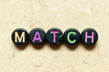 Tahta zemin üzerinde kelime eşleşmesi ile siyah renk yuvarlak alfabe harf bloğu