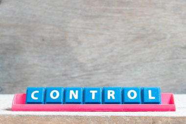 Ahşap arkaplanda kırmızı renk rafında kelime kontrollü döşeme alfabesi harfi