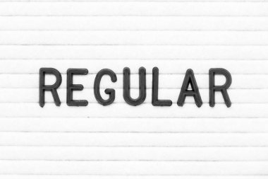 Beyaz keçeli tahta arka planında düzenli olarak siyah renkli harf