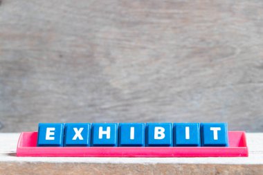 Ahşap arkaplanda kırmızı renk rafında kelime sergisi olan döşeme alfabesi harfi