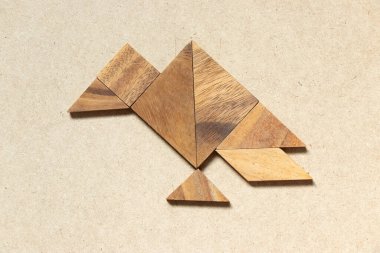 Ahşap arka planda akbaba şeklinde ahşap tangram.