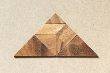 Tahta arka planda üçgen şeklinde ahşap tangram
