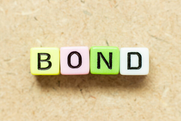 Color alphabet letter block in word bond on wood background