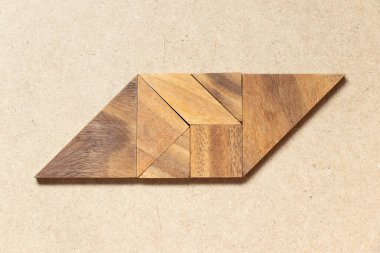 Ahşap zemin üzerinde paralel kenar şeklinde ahşap tangram
