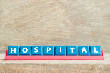 Ahşap zemin üzerinde kırmızı raflı kelime hastanesi harfli döşeme harfi