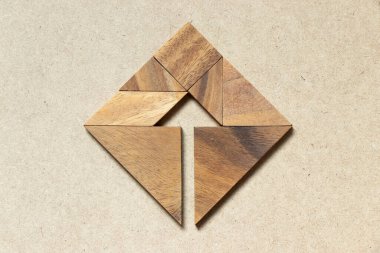 Tangram bulmacanın ahşap arka plan (iş yönetmeni ve karar kavramı üzerinde kare şeklinde ok gibi)