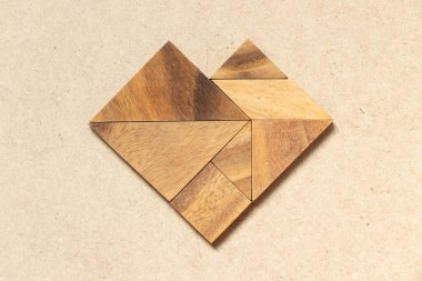 Ahşap arka planda kalp şeklinde ahşap tangram