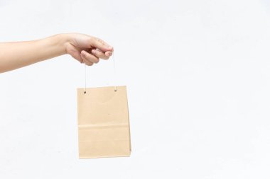 Hand of business woman hold brown paper shopping bag on white concrete background
