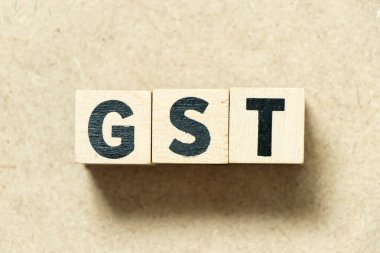 Ahşap zemin üzerinde kelime GST (Mal ve Hizmet Vergisinin kısaltılmışı) harfli alfabe bloğu