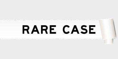 Yırtılmış gri kağıt arka planında yırtık parçaların altında nadir bulunan kelimeler var.