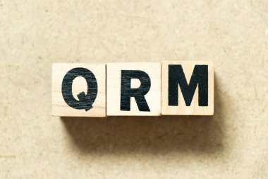Tahta zemin üzerinde QRM (Kalite Risk Yönetiminin kısaltması) harfli alfabe bloğu