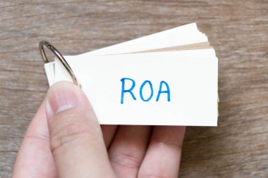 Kelime ROA ile el yazısı olan el bilgisayarı flaş kartı (mal varlığının dönüşü kısaltması) ahşap arka planda