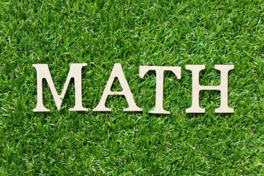 Yeşil çimen arka planında kelime matematiğinde ahşap harf