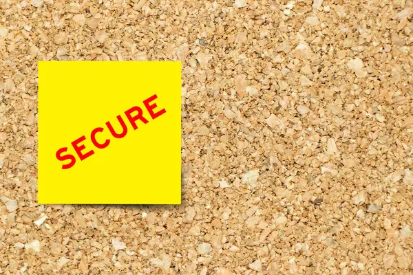 stock image Yellow note paper with word secure on cork board background with copy space