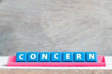 Ahşap arkaplanda kırmızı renk rafında kelime endişesi olan döşeme alfabesi harfi