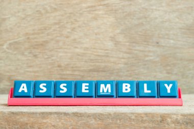 Ahşap zemin üzerinde kırmızı renk rafında kelime montajı ile harf döşeme alfabesi